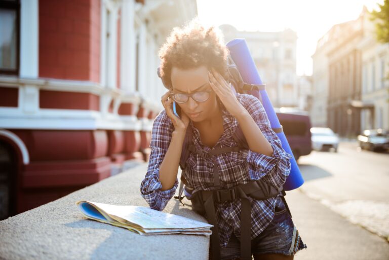 A person on the street using a phone to manage travel anxiety with AI tools.