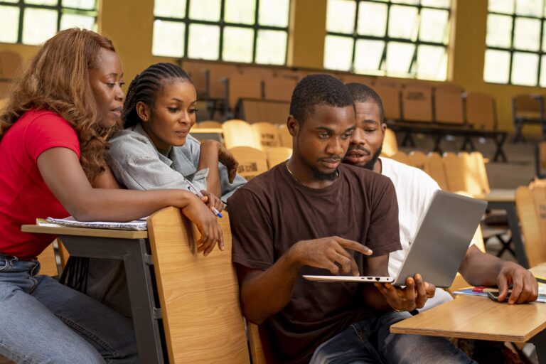 Group of students in Nigeria studying cybersecurity on laptops in a classroom
