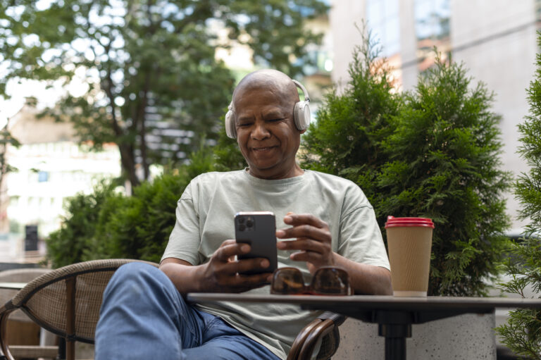 An elderly African grandparent using a senior-friendly smartphone with a big screen and loudspeaker — best phones for older adults in 2025